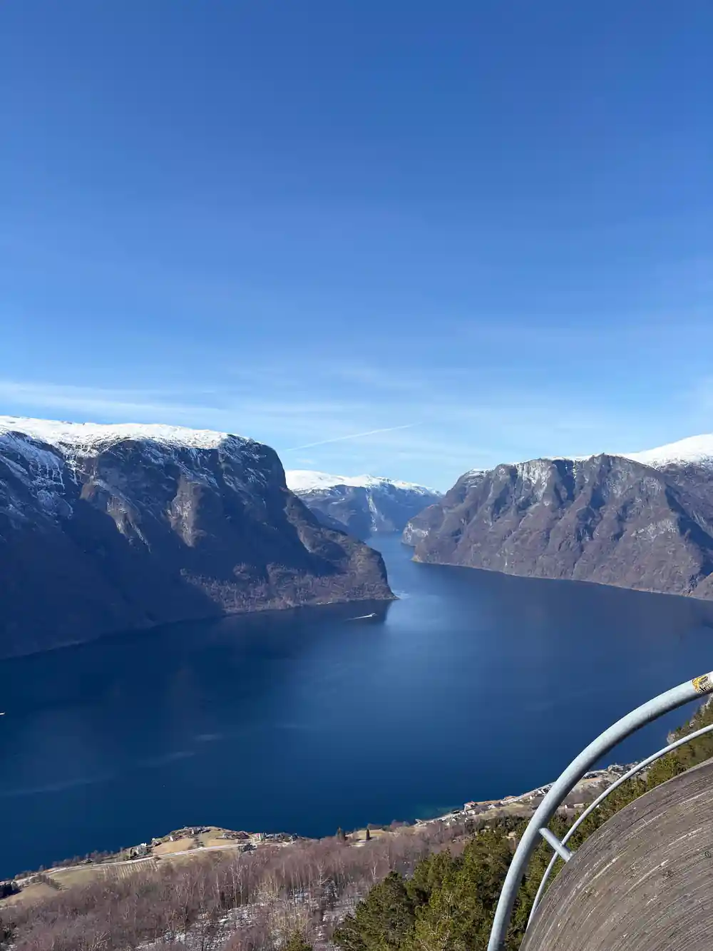 The fjord in deep blue between steep walls under a clear sky