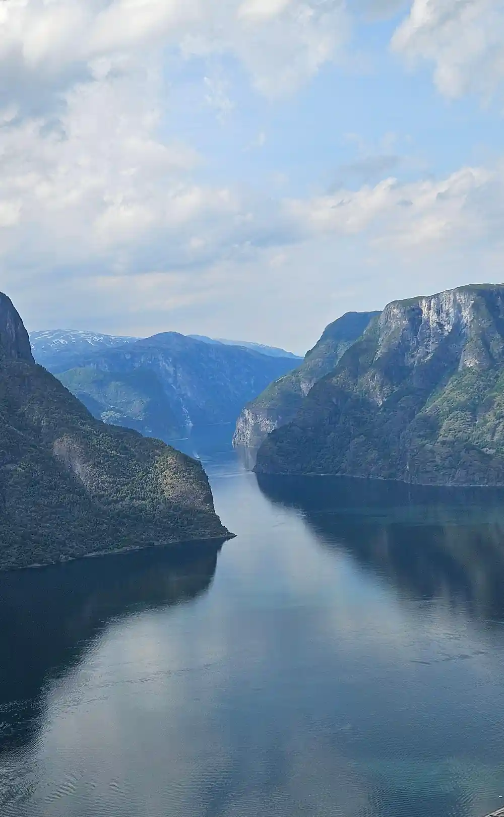 The fjord narrowing into the distance between snow-streaked walls