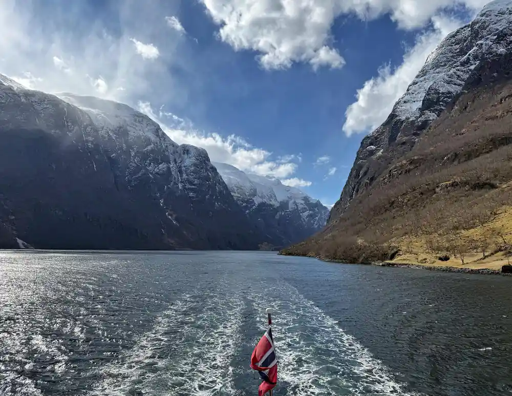 The flag and the wake as the boat leaves the narrow arm