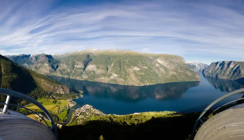 A flat-topped mountain wall reflected in still fjord water