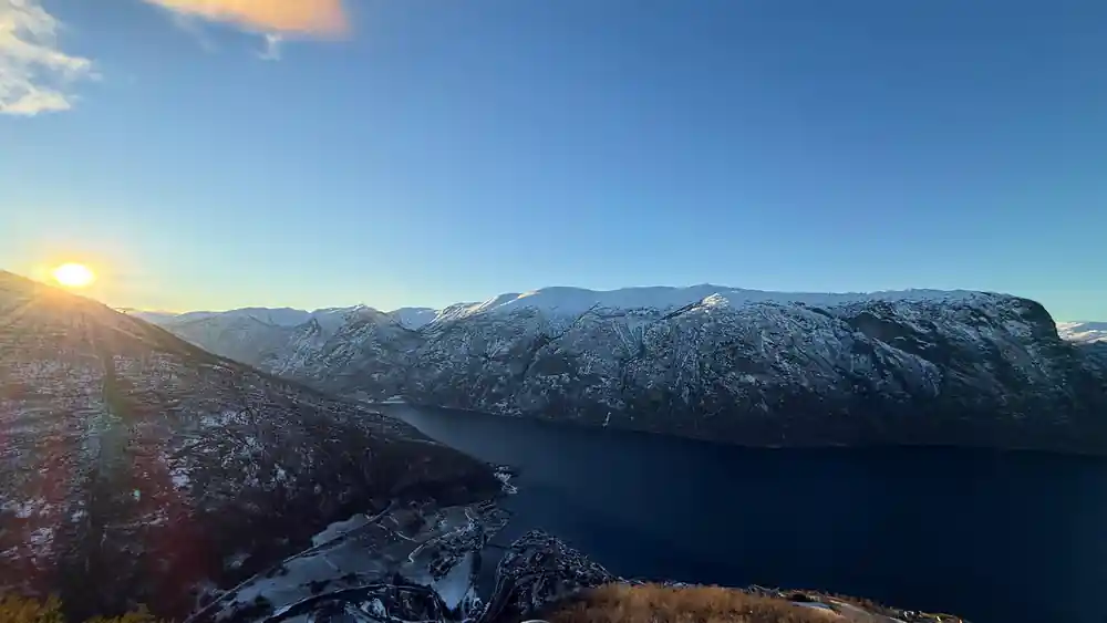 A long snow-dusted ridge above the fjord in flat winter light
