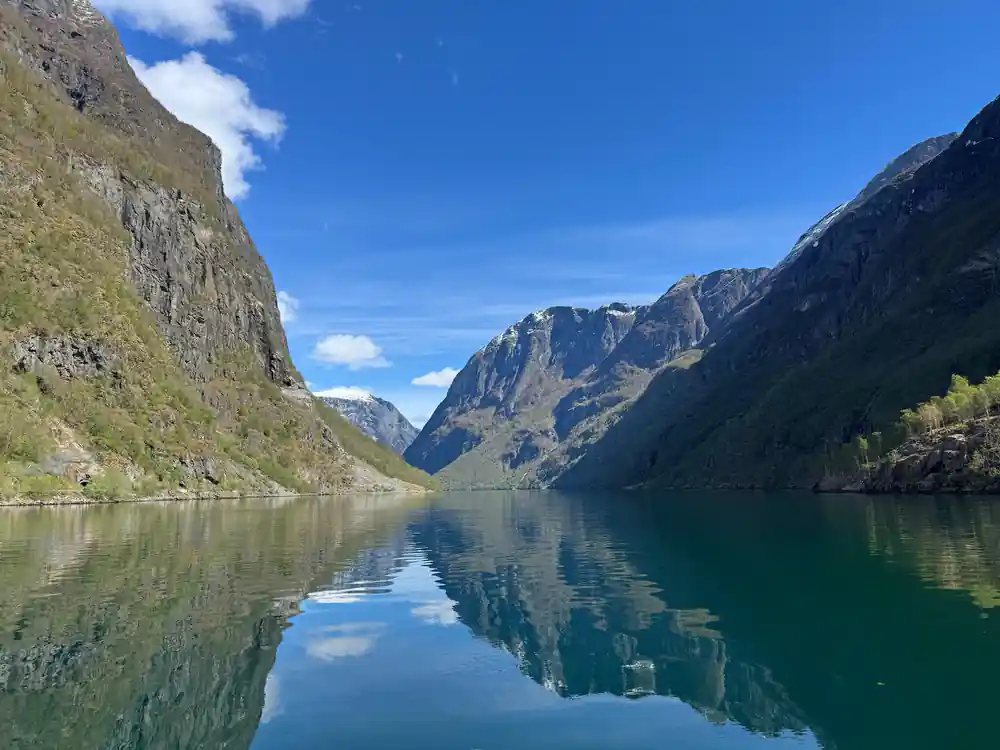 The narrow fjord arm reflected perfectly in still water