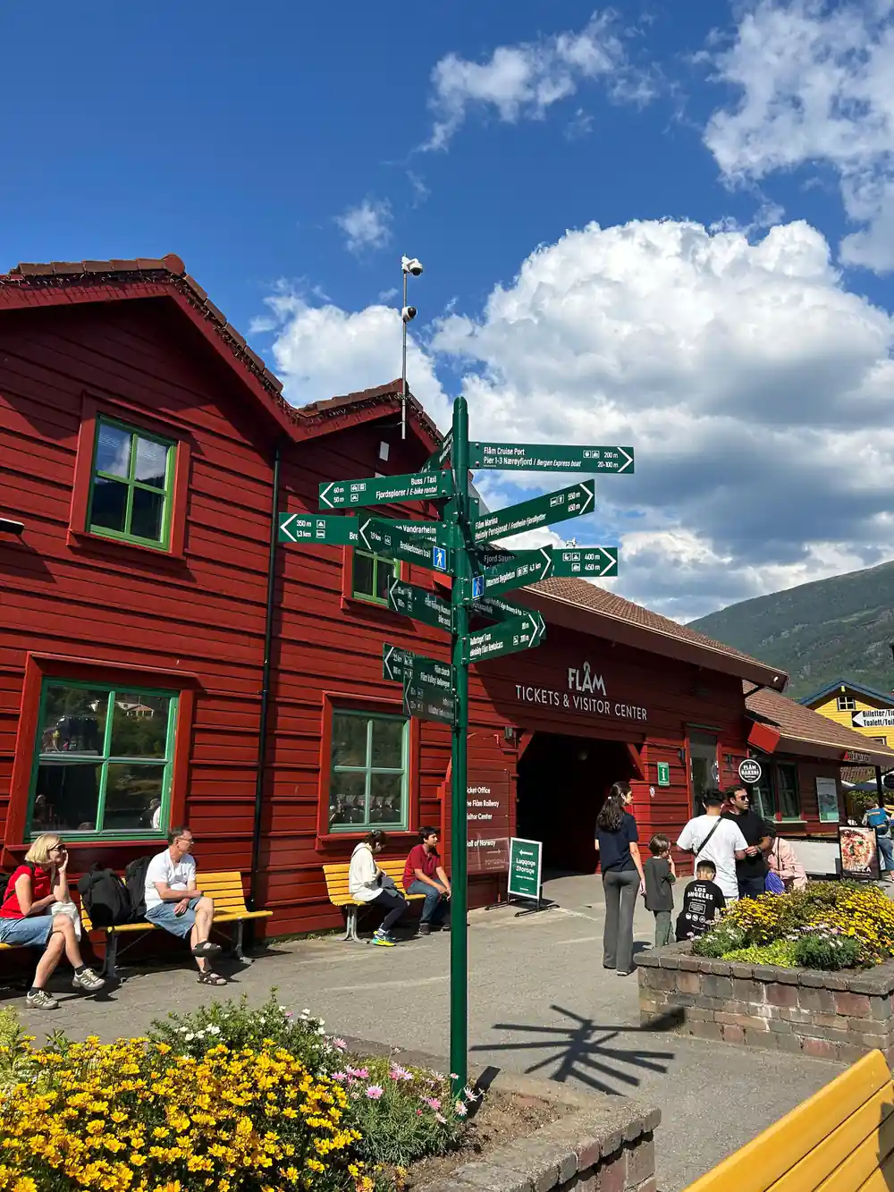 The red timber visitor centre at Flam with signposts and benches